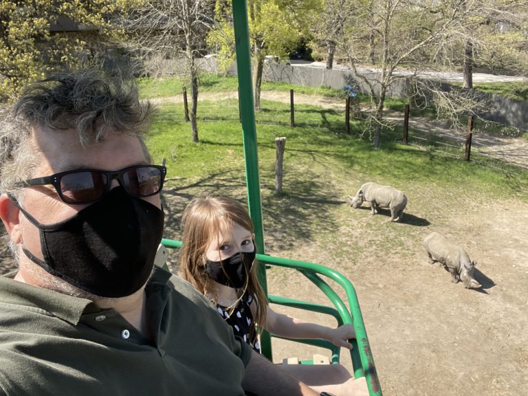 Me and K, in the 'Skyfari' at the Omaha Henry Doorly Zoo, above two rhinoceri.